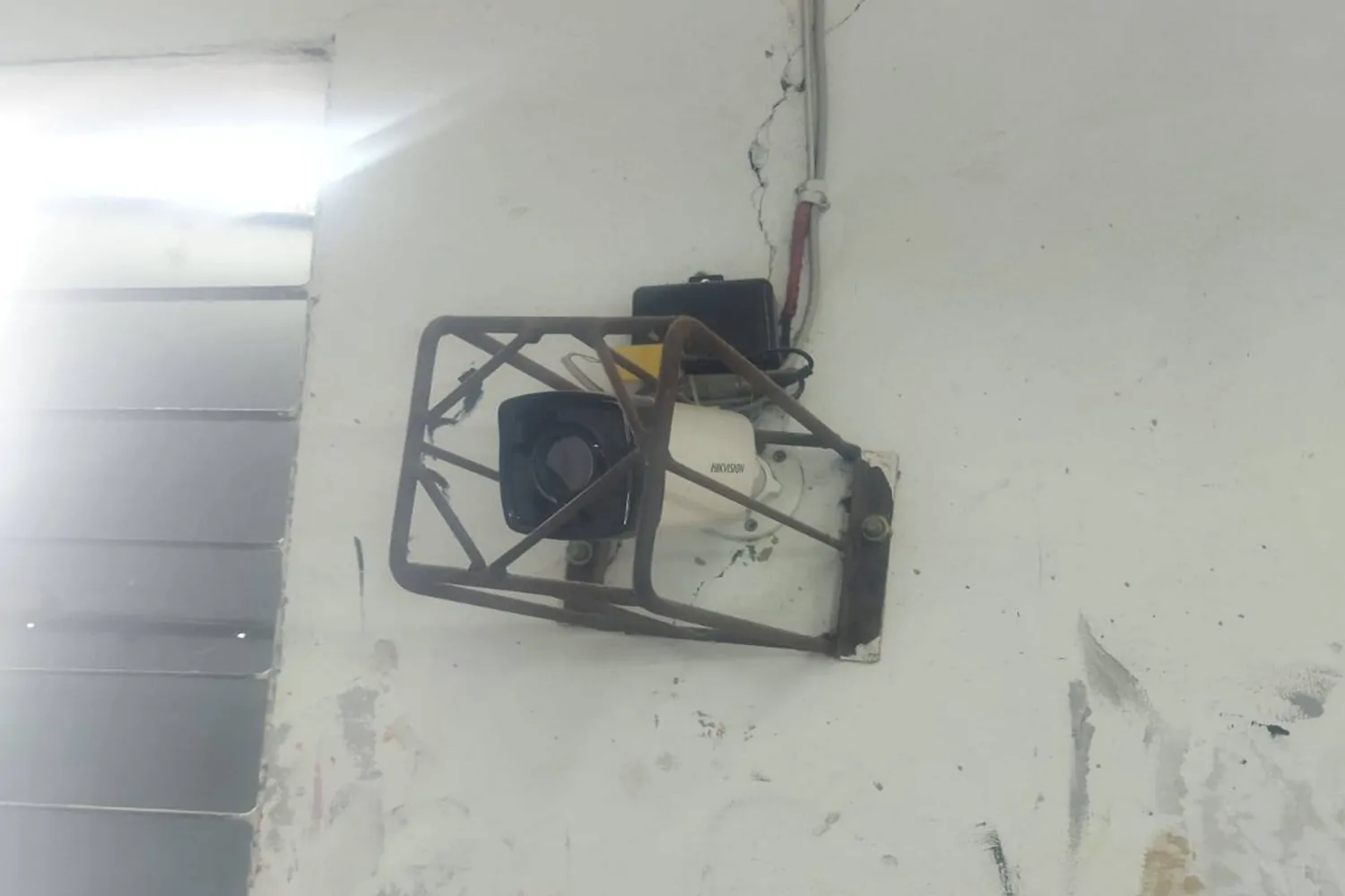 Hikvision CCTV camera installation with protective metal cover on wall for secure surveillance
